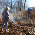 Woman and man burning prairie