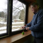 Man inspects window.