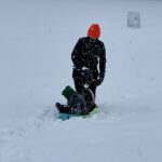 Woman pulls sled in snowstorm
