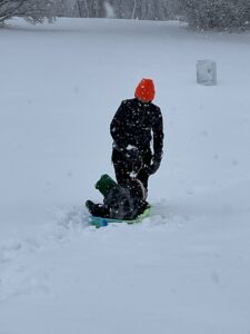 Woman pulls sled in snowstorm