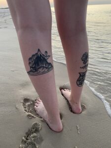 Tattoos on legs at beach