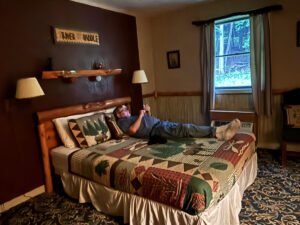 Man stretches out on cabin themed quilt