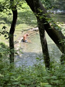 Young man with feet in cool water of Twin Springs, Decorah, IA