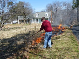 Man with rake to pull fire along.