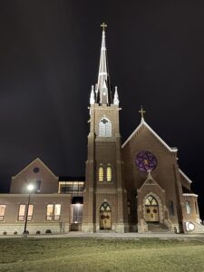 Church steeple lit up at night.