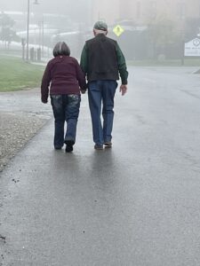 Couple walk through mist on an autumn day.