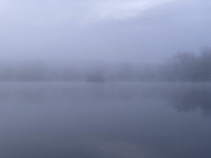 Fog over lake so island is hard to see.